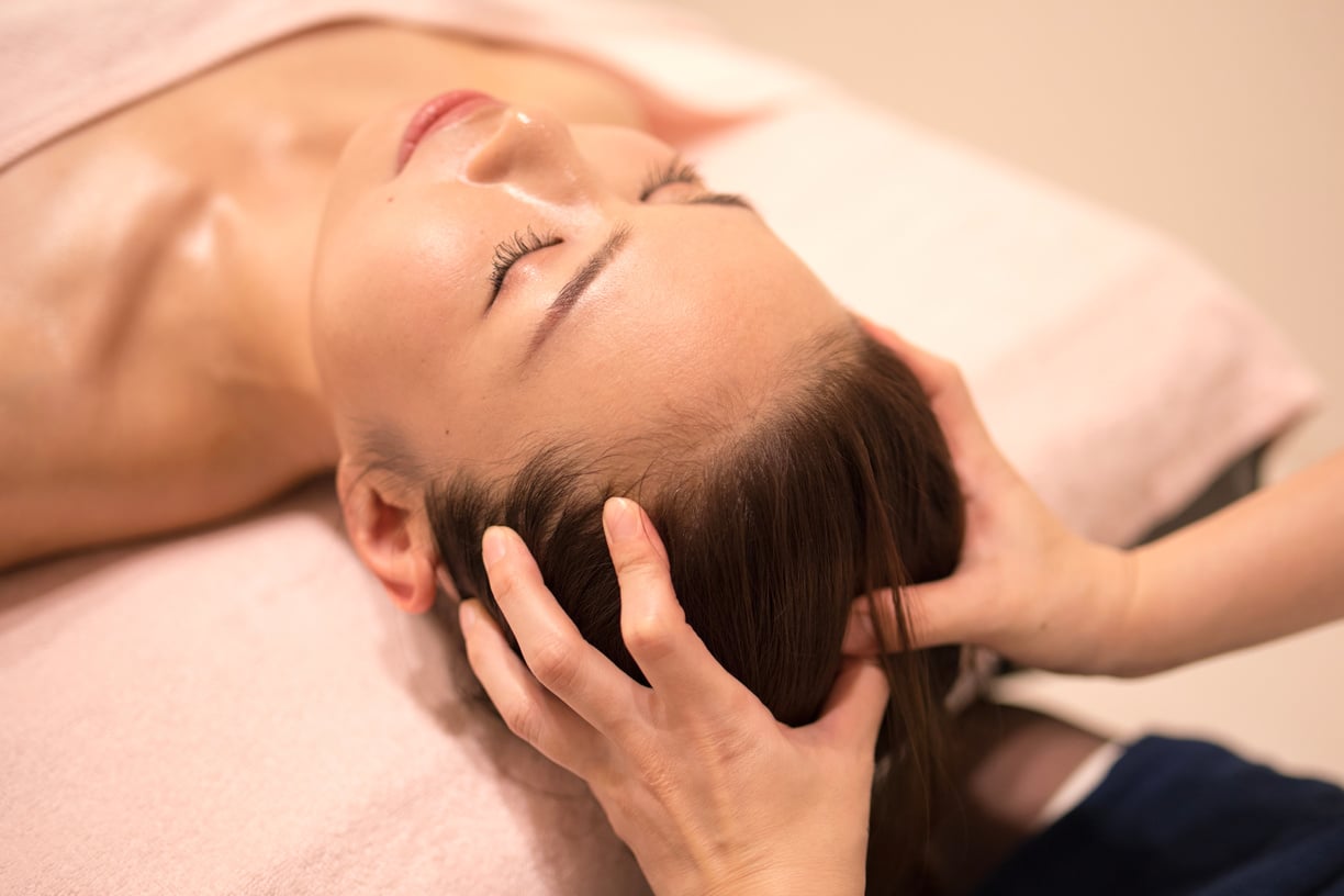 woman receiving oil massage on head